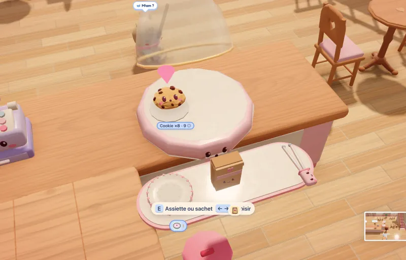 Capture du jeu : un cookie souriant attend sur la vitrine, à côté d’une assiette et d’un sachet.
